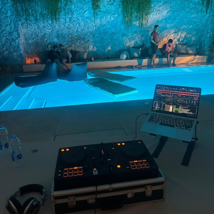 Poolside open-air set, the water lit turquoise beside the booth